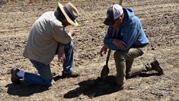 Photo: Two people in discussion in a field